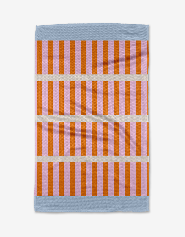 The Red Glow tea towel by Happy Hemera features vertical orange and red stripes, three horizontal beige bands, light blue top and bottom edges, and is crafted from recycled materials.