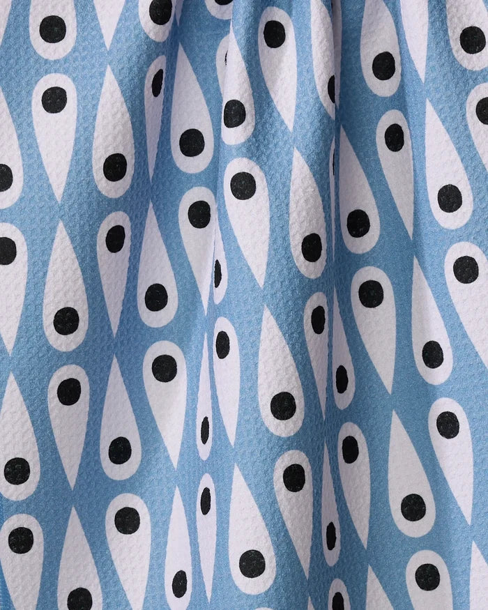 A close-up of the Retro Rain tea towel by Anette Heiberg shows its blue and white teardrop pattern with black dots, creating an eye-like geometric design on slightly textured recycled fabric—ideal for eco-friendly kitchens.