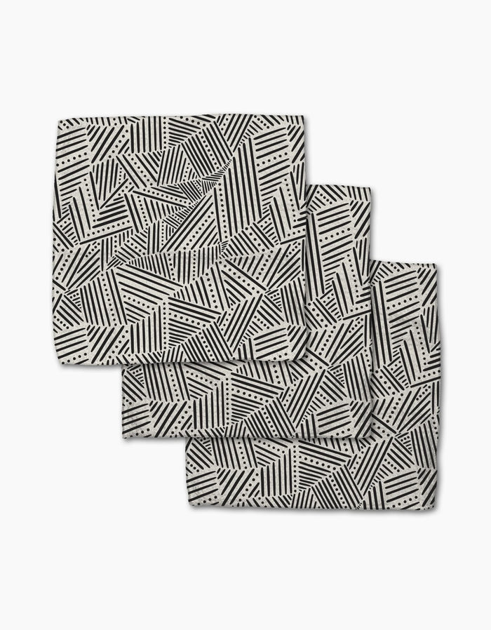 The Rhythm Current Stripes dishcloth set by Sarah Daugherty features three folded rectangular napkins with a black and white geometric pattern, made from recycled materials for a chic, eco-friendly addition to your home.
