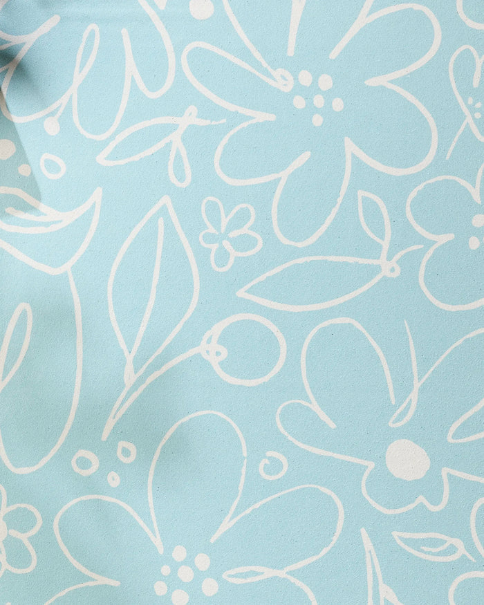 River Blossom by Sara Mari features a light blue background with a white, hand-drawn floral pattern—a playful, sketch-like design that brings charm and style to any recycled yoga towel.