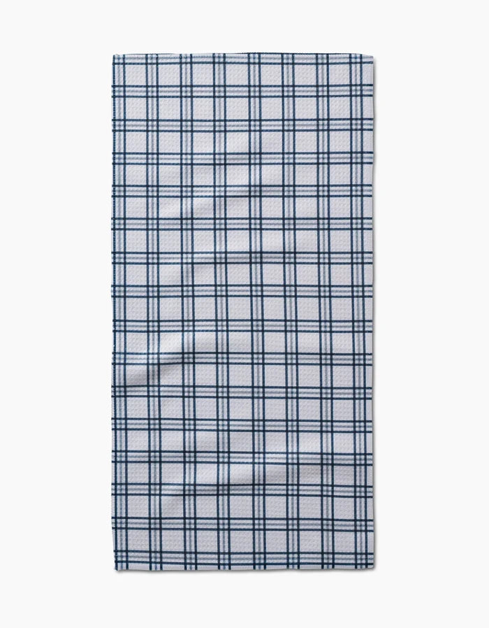 The Roma bar towel by Kelsi Fullmer is a rectangular, white Geoweave fabric towel with a dark blue plaid pattern of evenly spaced lines, shown laid flat on a plain white background.