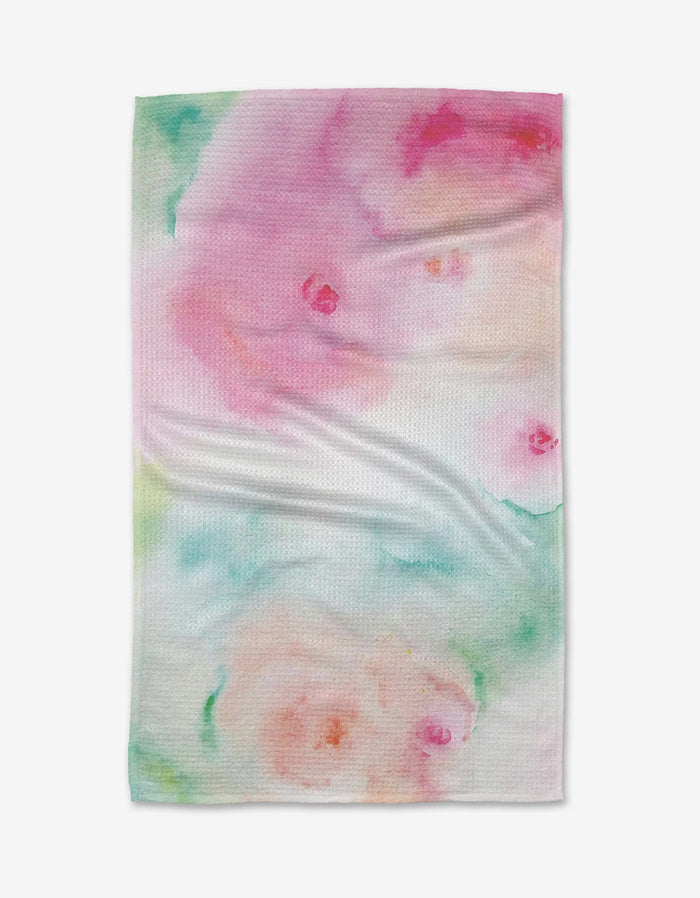 The Stefanie Bales Rose Garden kitchen towel features a soft, watercolor-inspired pattern in pink, green, and peach with subtle swirls and gentle color blending.