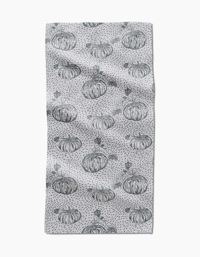 The Sage Pumpkin Field bar towel by Charlie Rowan Designs features hand-drawn pumpkins and dark gray dots evenly spaced across Geoweave fabric, creating a charming pattern on a slightly textured surface.