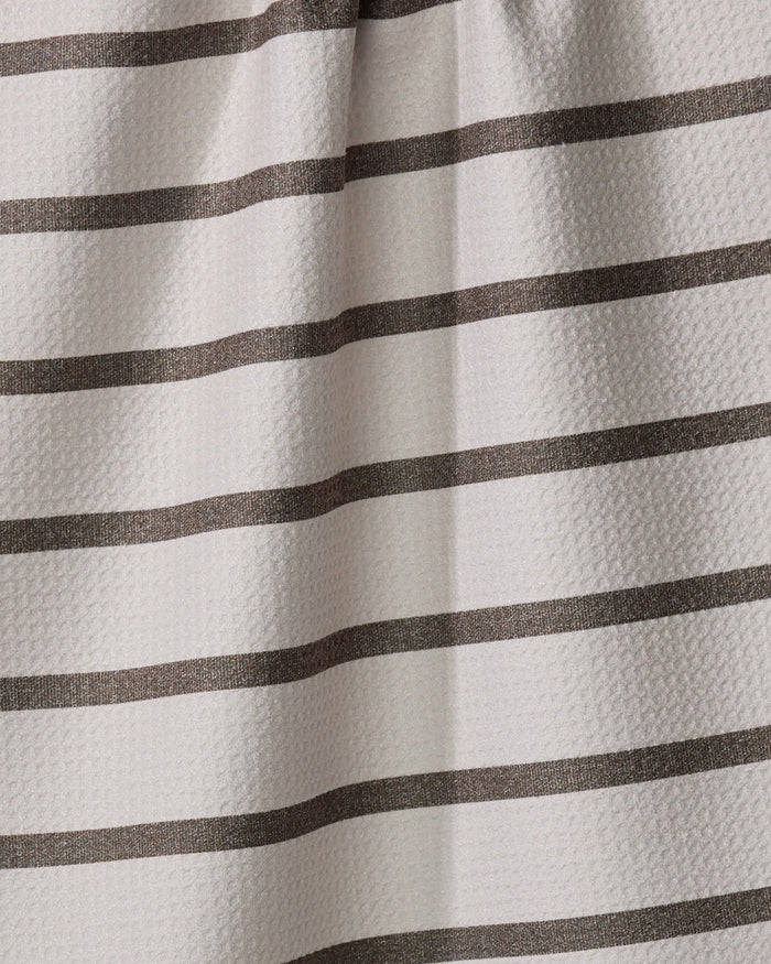 A close-up of the Jenny Keller Salt Air Stripe tea towel shows its textured surface with evenly spaced horizontal dark brown stripes on a light beige background. Made from recycled materials, the fabric has slight folds and subtle shadows.