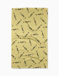A yellow GEOMETRY Salted vs Unsalted Tea Towel with a waffled texture, scattered black “BUTTER” pattern, and small “XX” symbols. Made from recycled materials and shown laid flat with slight wrinkles.
