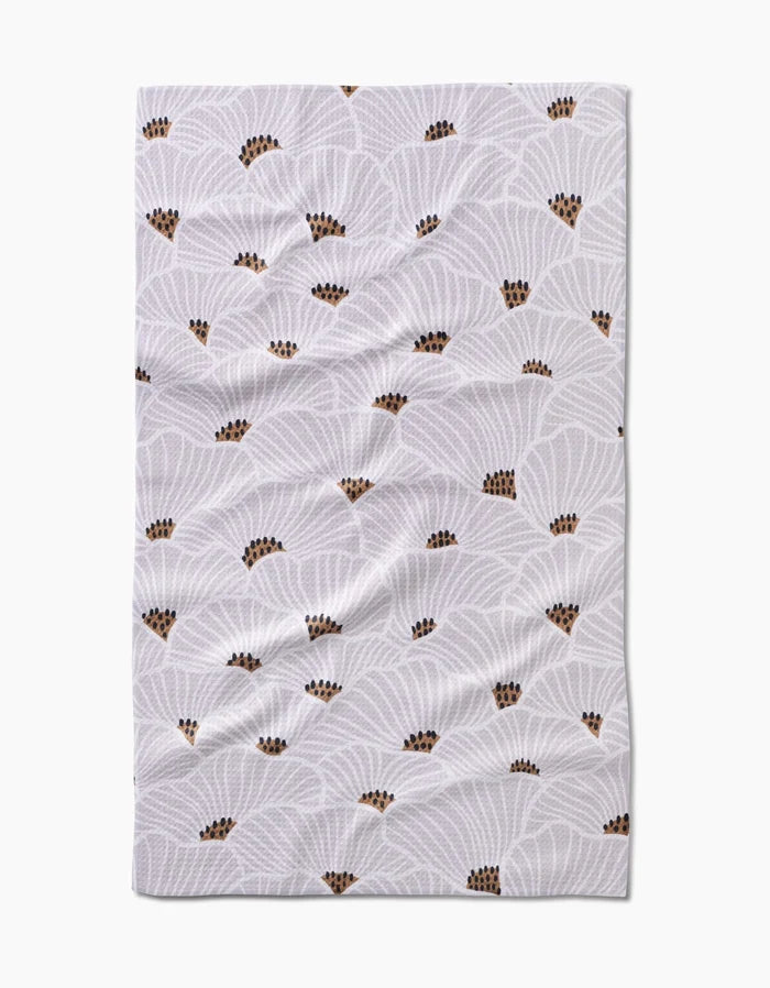 The San Diego Tea Towel by Amy MacCready features a white Geoweave™ fabric with a repeating pattern of overlapping, fan-shaped light grey designs and small brown and black accents. The rectangular towel may appear slightly wrinkled.