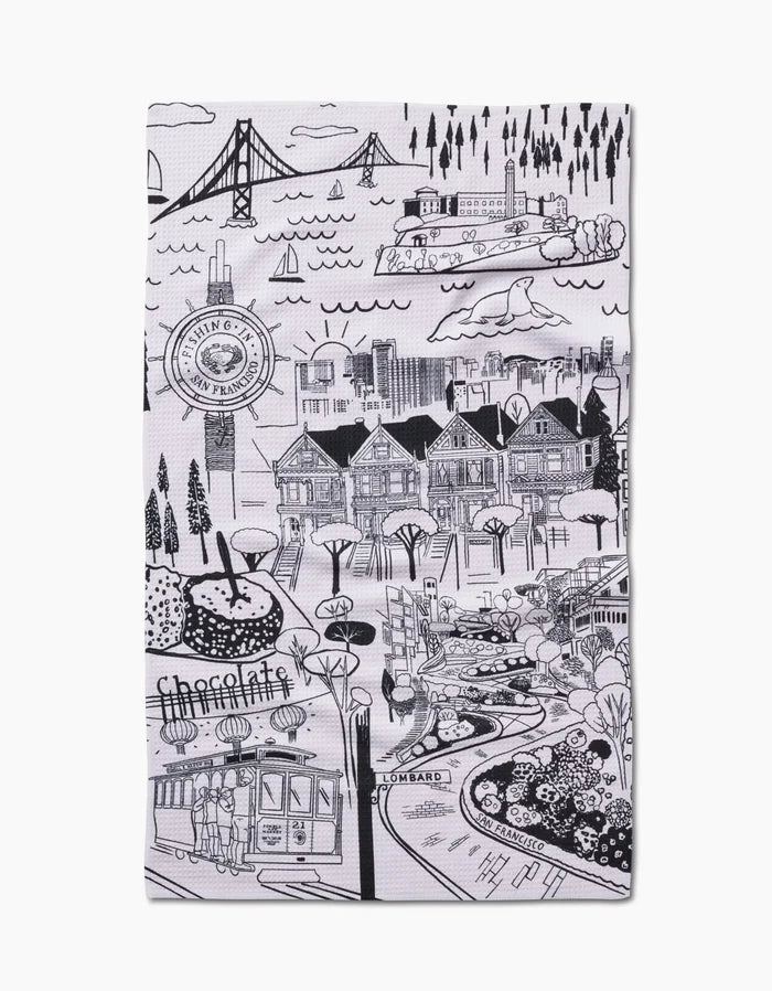 This black and white San Francisco tea towel by Elisabeth Wing shows landmarks like the Golden Gate Bridge, cable car, Painted Ladies, Lombard Street, and trees—printed on durable Geoweave fabric.