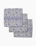 Three folded Geometry Santorini Tile dishcloths, featuring blue nautical patterns of fish, crabs, seashells, and checkered squares on beige Geoweave fabric, are arranged overlapping on a white background.