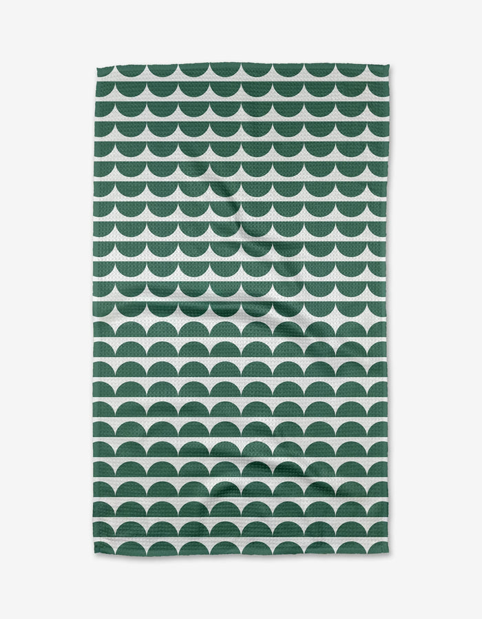 The Buy Guides Scallops - Evergreen Tea Towel displays dark green and white semi-circles on white, crafted from post-consumer recycled materials. Its eco-friendly, scalloped design is featured as it lies flat.