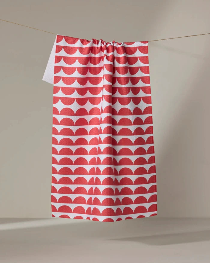 The Buy Guide’s Scallops - Red tea towel, ultra-absorbent and featuring a red and white scallop pattern, hangs from a clothesline against a neutral background.