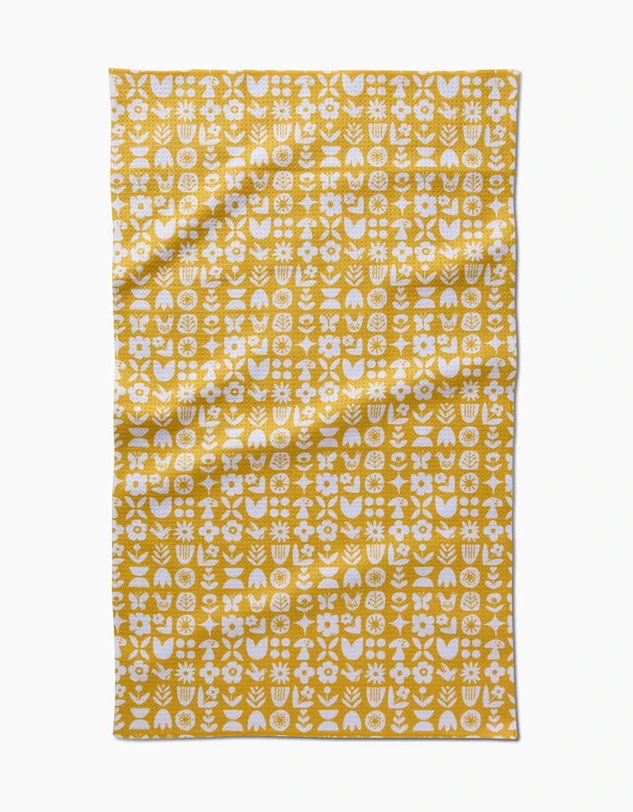 The Kayla Ann “Scandi Spring” Tea Towel features a yellow background with white abstract floral and geometric patterns in neat rows and columns, crafted from Geoweave fabric for a modern, textured look.
