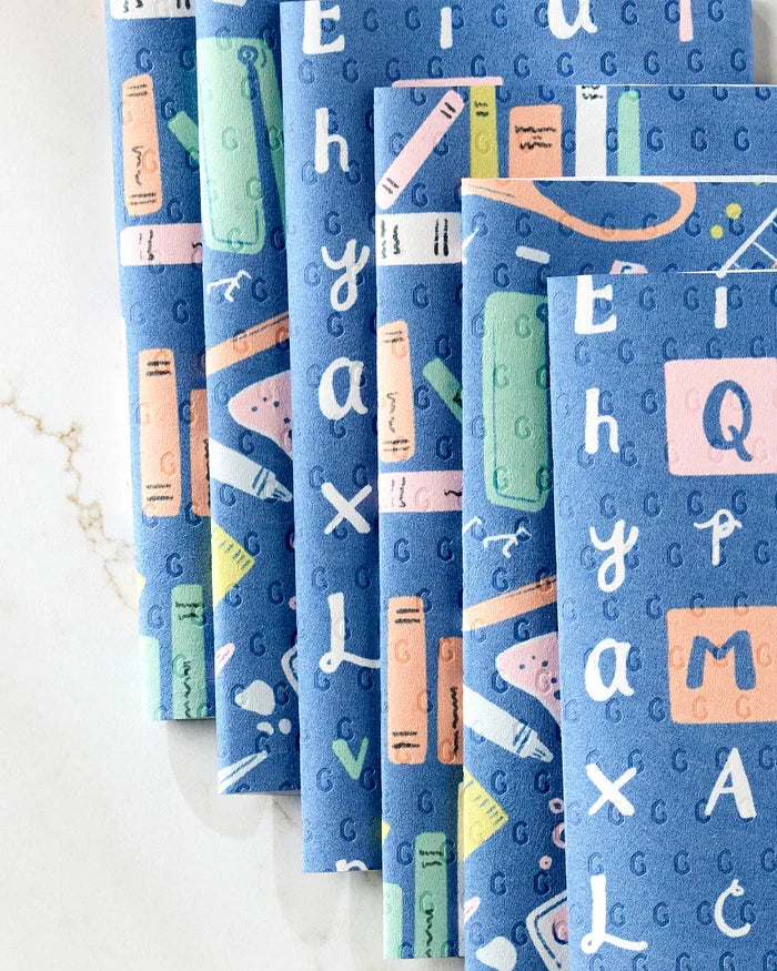 The School Days reusable paper towels by Amy MacCready feature blue fabric with colorful books, rulers, pencils, and white alphabet letters—a fun, eco-friendly alternative to disposables shown on a light marbled surface.