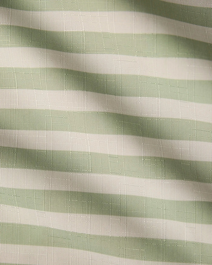 Seagrass by Geometry features light green and white horizontal stripes on textured, recycled tablecloth fabric, with soft waves and shadows adding gentle movement and depth.