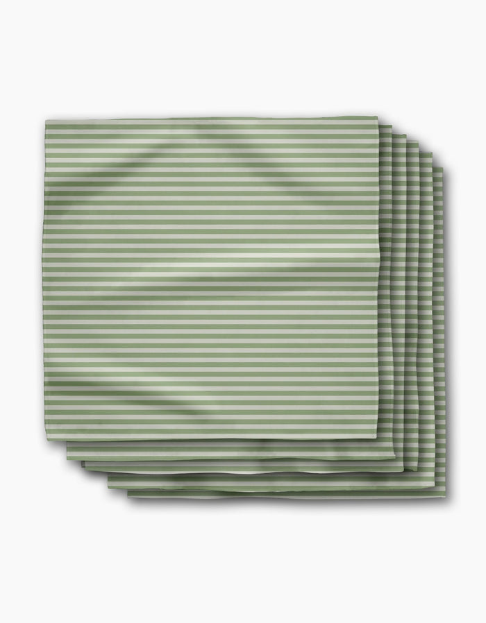 Geometry’s Seagrass Dinner Napkin Set includes four neatly folded cloth napkins made from recycled materials, featuring thin green and white horizontal stripes on a white background.