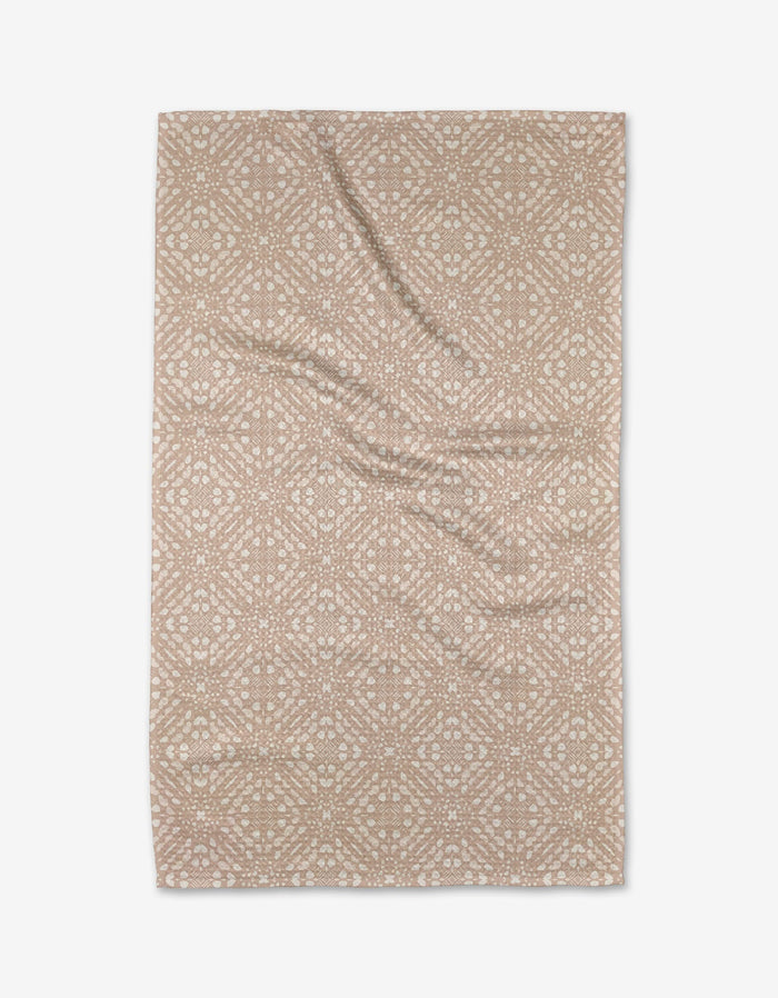 Seeds and Nuts Neutral by Twig + Spark: a beige rectangular tea towel featuring a white geometric and floral print. Made from soft recycled materials, the fabric is slightly wrinkled and shown flat on a white background.