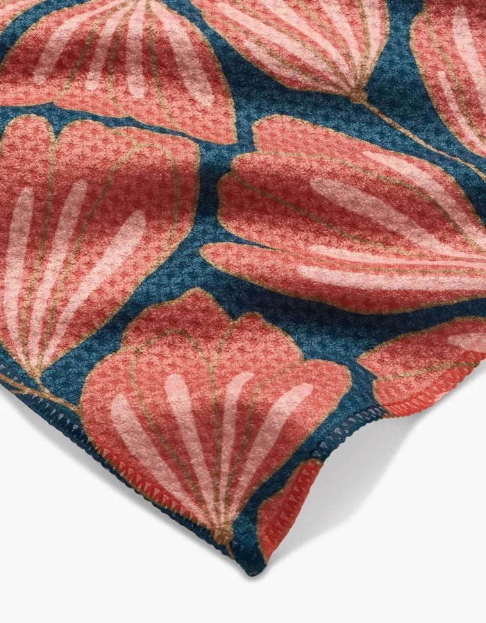 Close-up of Amy MacCready’s Sheila Geoweave fabric, featuring large pink stylized flower petals on a dark blue background, with visible neat coral stitching along the edge.