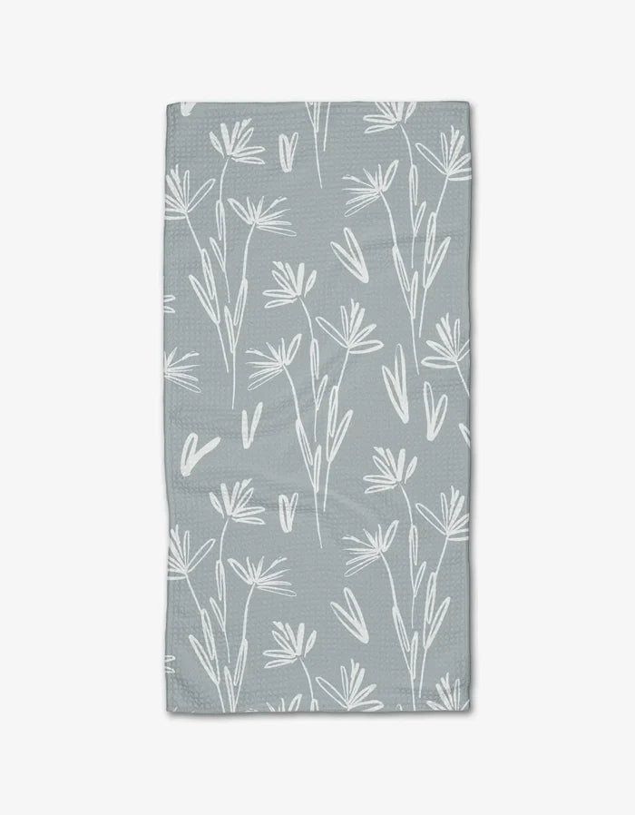 The Sketchbook Floral Bar Towel by Toboggan Avenue features a white, hand-drawn floral and leaf design on light gray Geoweave fabric for enhanced absorbency and durability.