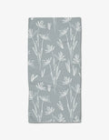 The Sketchbook Floral Bar Towel by Toboggan Avenue features a white, hand-drawn floral and leaf design on light gray Geoweave fabric for enhanced absorbency and durability.