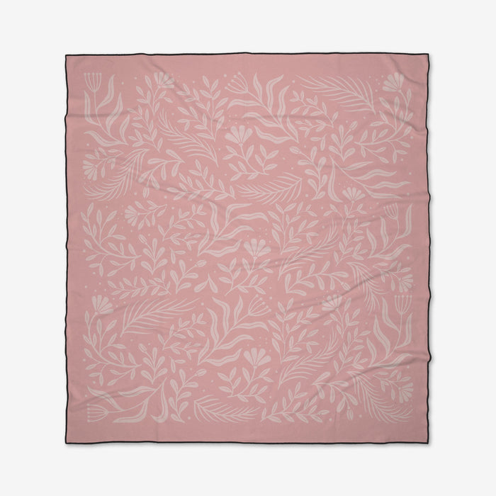 The Small Steps square pink Geometry Micro-loop Beach Blanket by Small Steps features a subtle white botanical design with leaves and flowers and is finished with a thin black border around the edges.