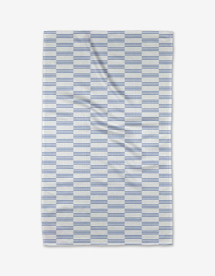 The Buy Guide’s Small Stripe - Navy towel features a rectangular white design with navy dashed stripes, made from ultra-absorbent Geoweave fabric. Subtle creases provide texture, shown on a white background.