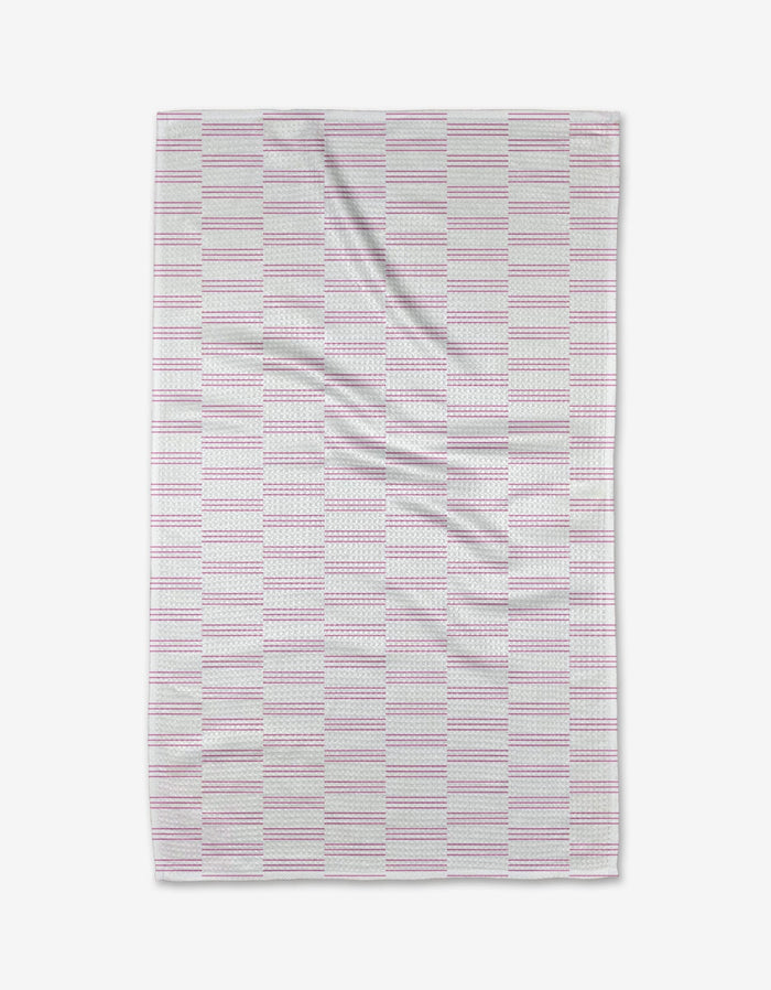 The Buy Guide’s Small Stripe - Pink Tea Towel features a rectangular design with pink and gray stripes on white. Made from soft, recycled fabric, it has gentle wrinkles for a cozy, lived-in appeal.