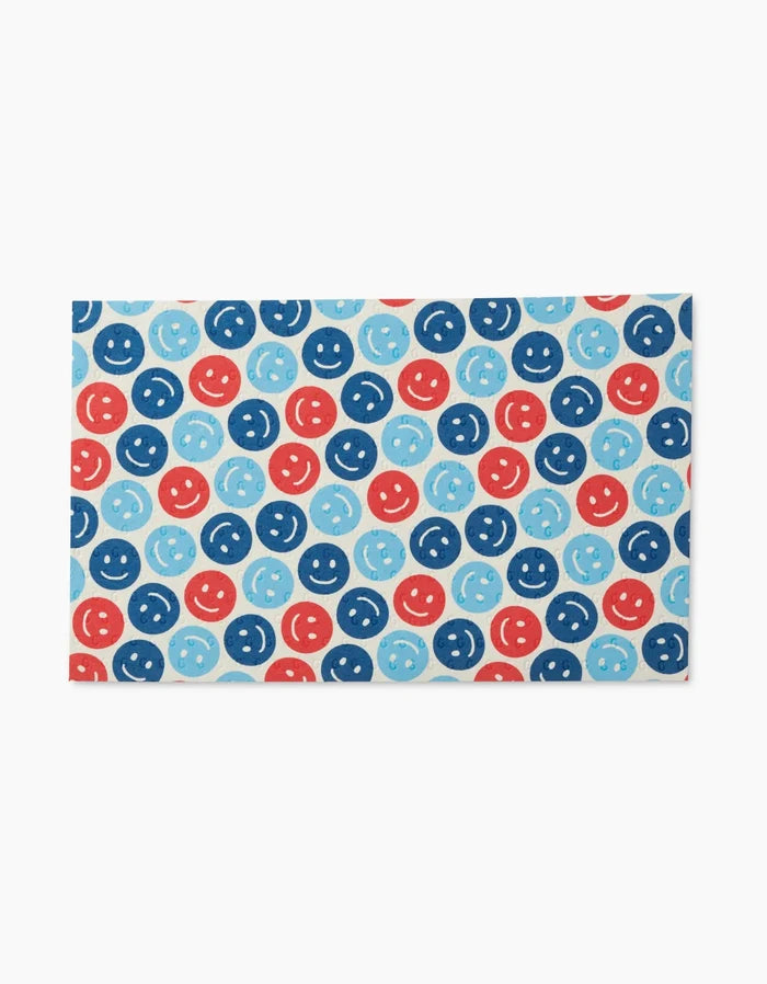 Rows of blue, light blue, and red smiley faces with playful expressions decorate the Smiley Face July Blue Not Paper Towels from Hufton Studio—a rectangular, eco-friendly card with a clean white background.