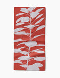 The PrintedPlant Smoketree bar towel showcases a bold red background with a white, stylized leafy plant silhouette extending vertically on its Geoweave fabric.