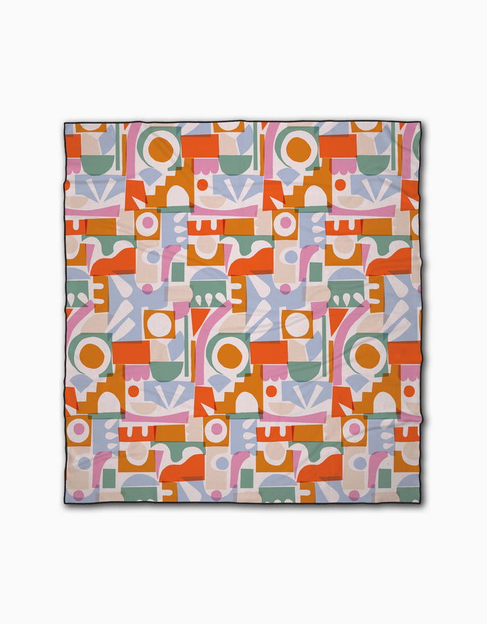 Soft Cutouts Garden by Claire Iglesias is a square fabric with a vibrant abstract geometric pattern in orange, pink, green, purple, and white on a light background, featuring repeating circles, lines, arches, and rectangles.