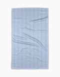The Geometry “Soft Summer Blue” tea towel features thin vertical blue and white stripes on ultra-absorbent Geoweave fabric, displayed flat with subtle creases against a plain white background.