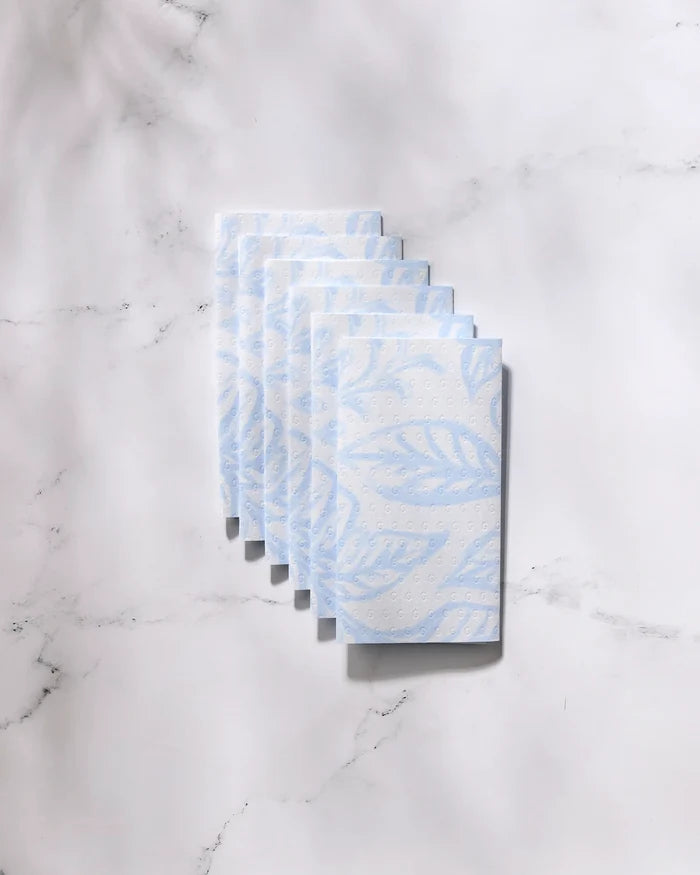 Six eco-friendly "Something Blue" paper towels by GEOMETRY, featuring a subtle blue leaf pattern, are neatly stacked on a white marble surface.