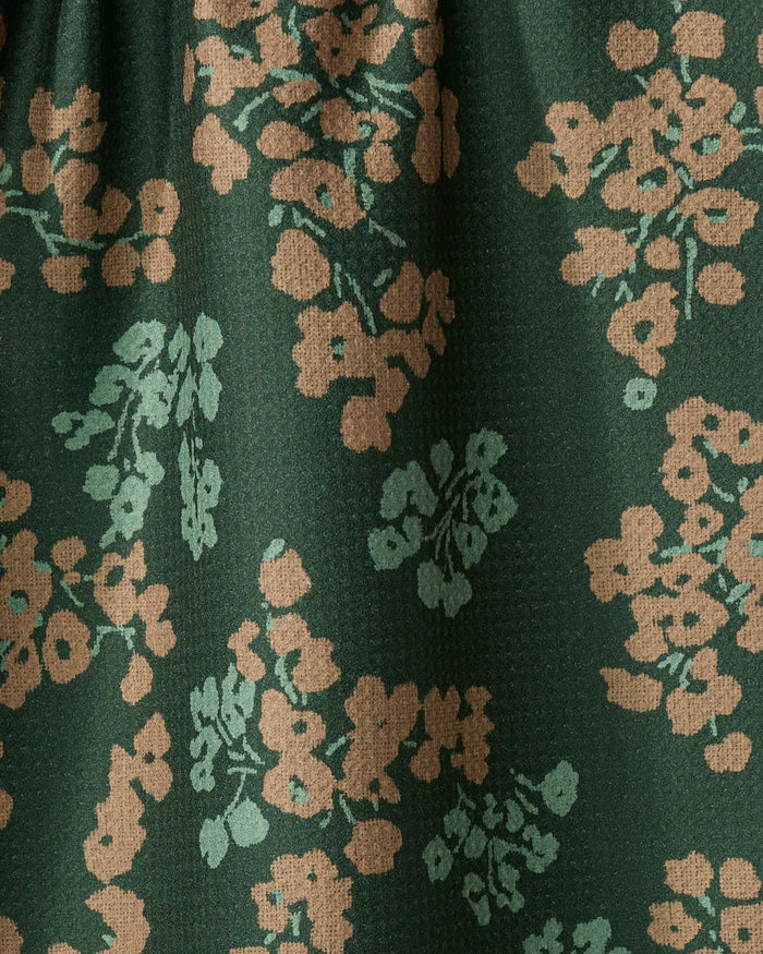The Geometry Sonnet Forest dish towel features dark green textured fabric adorned with beige and light green floral clusters, combining absorbency and charm for practical kitchen use.