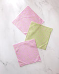 Three square washcloths from GEOMETRY’s Speckle Green Pink set—two pink with multicolored dots, one light green with pink, yellow, and white dots—made from recycled materials and crafted for super absorbency.