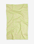 The Speckle Green blanket by GEOMETRY features a light green color with small, scattered pink dots. Made from recycled materials, it is shown flat with visible folds and creases on a white background.