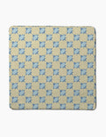 The Spiky quilt by Geometry features a repeating blue eight-pointed star pattern on beige, crafted from recycled materials. Shown laid flat on a plain white background.