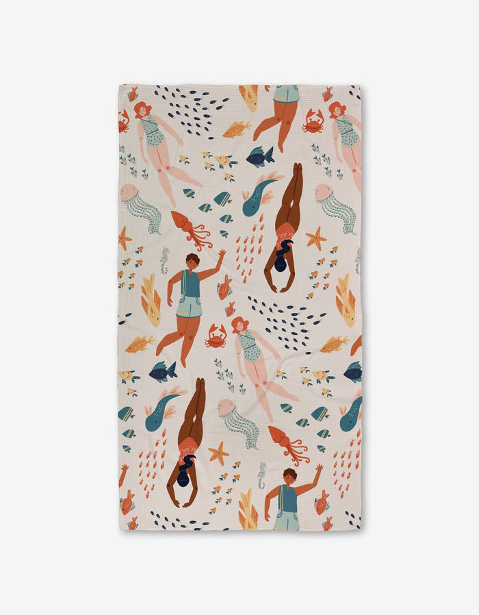 The Spirit of the Ocean Luxe Bath Towel by Janna Sue Design features diverse women swimming with sea life in blue, orange, and peach on a light background. Made with ultra-absorbent recycled materials for style and sustainability.