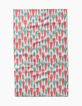 The Spring Carrot Hill tea towel by Hufton Studio displays orange carrots with green tops in neat rows across a white background.