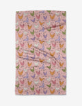 The Kayla Ann Spring Chickens tea towel features a pink background with colorful chickens in green, orange, purple, and white. Ultra-absorbent and slightly wrinkled for charm, it adds a playful touch to your kitchen.