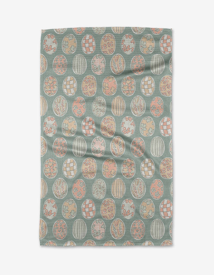 The Spring Easter Eggs kitchen towel by Hufton Studio is a rectangular recycled towel adorned with pastel-colored circular designs featuring floral and geometric motifs on a muted teal background.