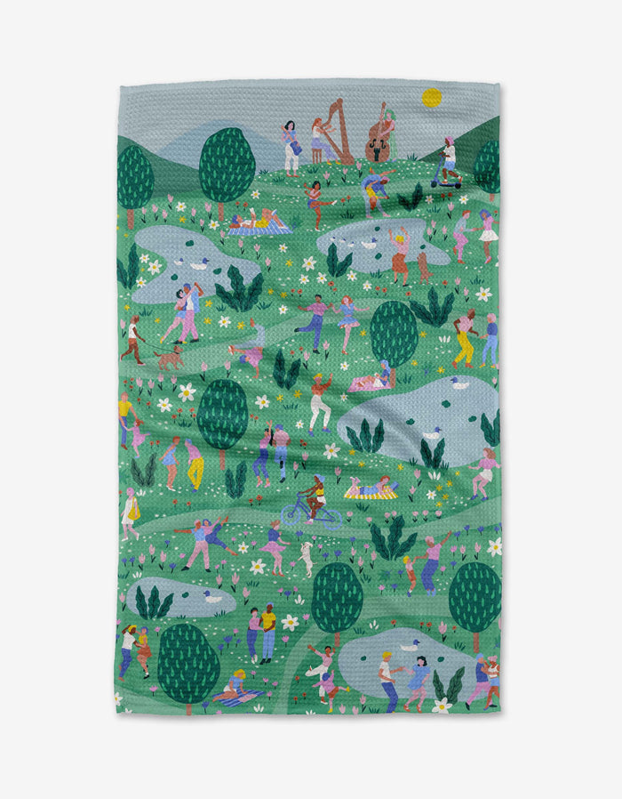Spring Festival by Ceyda Alasar is a vibrant Geoweave fabric blanket depicting people dancing, making music, and relaxing in a sunny park with trees, flowers, and rolling hills.