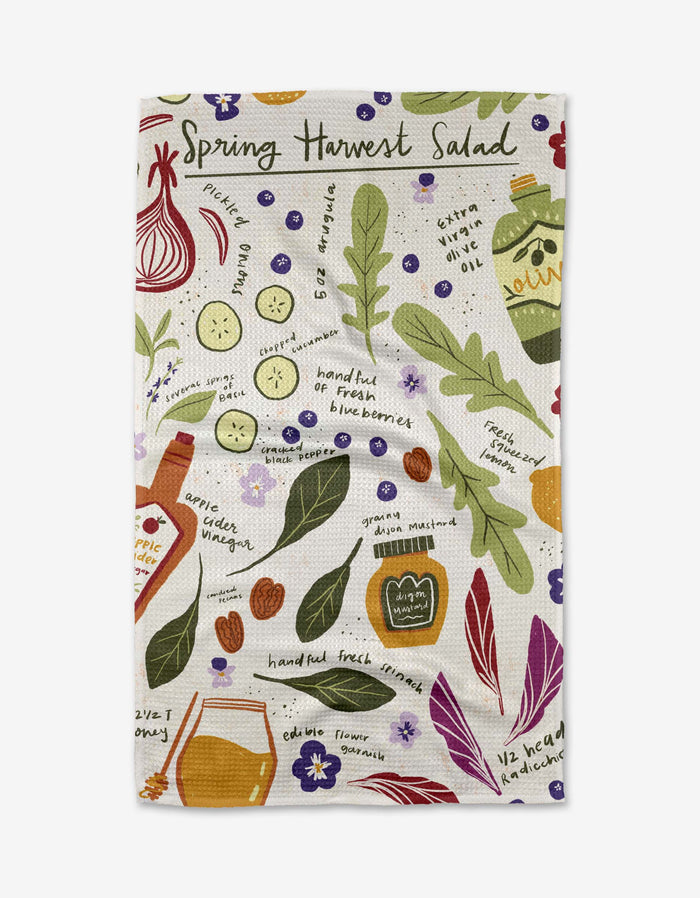 The “Spring Harvest Salad” tea towel by Janna Sue Design features eco-friendly fabric and charming salad ingredient illustrations—cucumber, leafy greens, red onion, blueberries, oil and vinegar bottles—with handwritten labels.