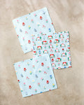 Three pastel blue "Spring House Blossom" kitchen towels by Ceyda Alasar rest on a beige surface: two with delicate floral prints and one with colorful houses and trees—cheerful designs perfect for any kitchen.