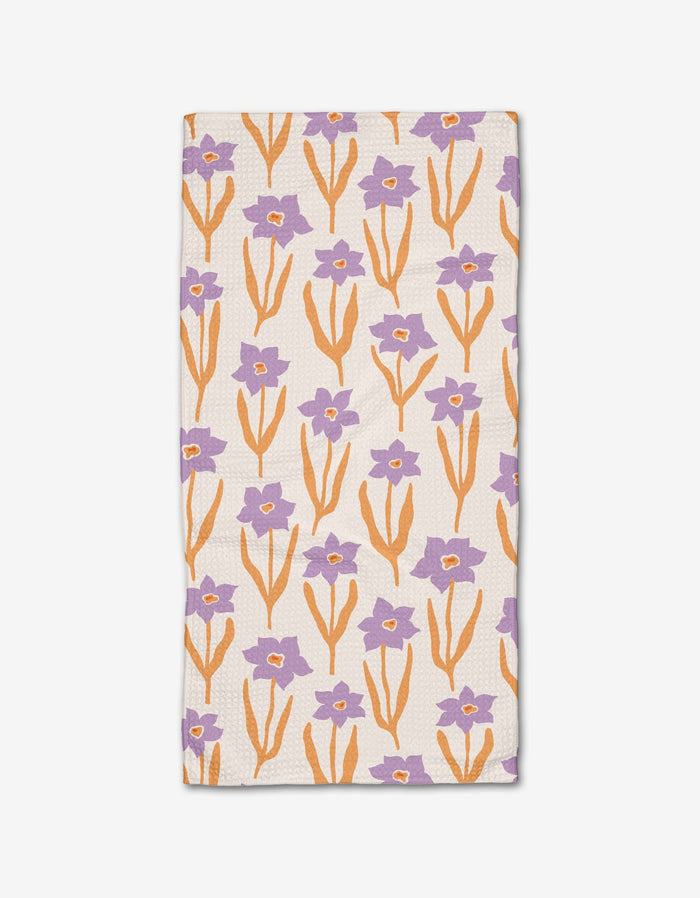 The Spring napkin by Kayla Ann is a rectangular Geoweave cloth featuring orange stems and leaves with purple flowers on a white background.
