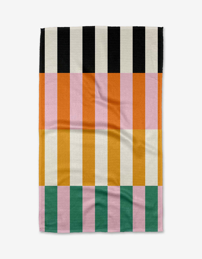 The Stacked Stripes blanket by Megan Roy features vertical color-block stripes in black, white, orange, pink, yellow, and green. This soft woven throw is crafted from post-consumer recycled materials.
