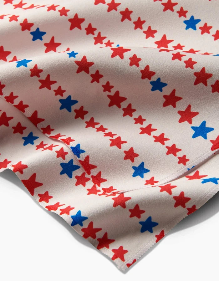 A close-up of Kayla Ann’s Starry Stripes shows white Geosuede fabric with red and blue stars in diagonal rows. The slightly wrinkled surface displays evenly spaced stars.