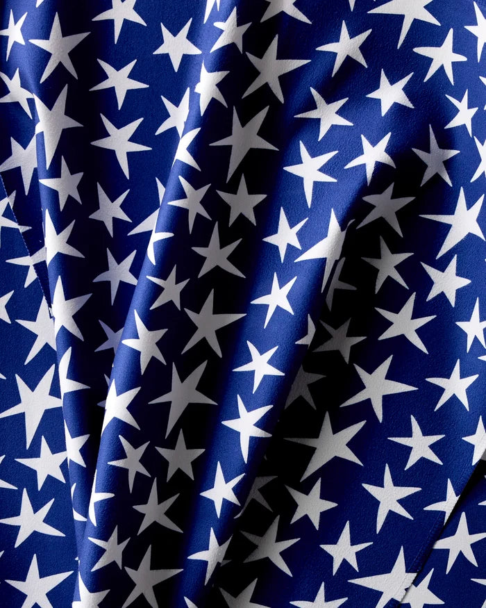 Mindfulnice’s Stars And Stripes features blue Geosuede fabric with white stars in assorted sizes, shown with soft folds and shadows for added texture—perfect for an elegant dinner napkin set.