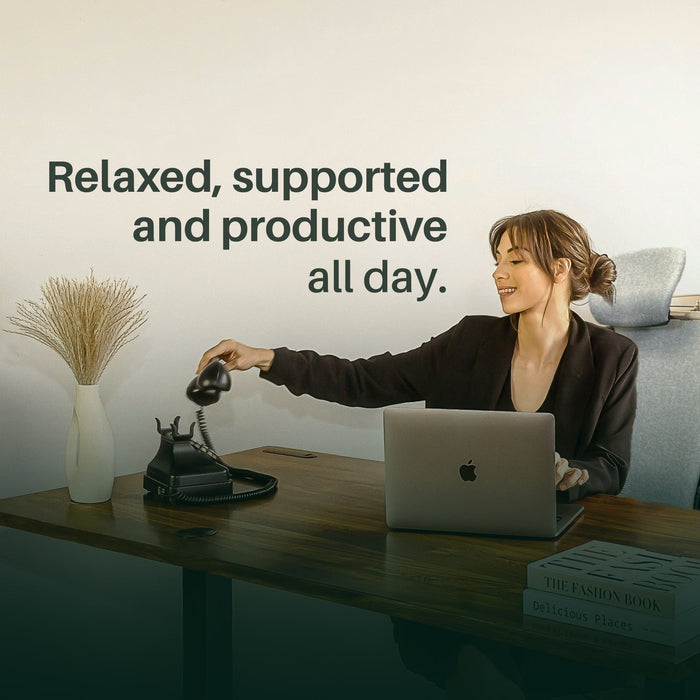 Woman in Steelcase Leap V2 office chair with headrest at desk, laptop open, taking phone call