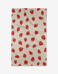 The Purely Kaylie Strawberry Shortcake blanket features a red strawberry pattern with green tops on beige, made from ultra-absorbent Geoweave fabric for style and comfort.