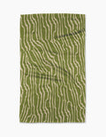 The Geometry Stripe Funk Grounds Green blanket, featuring an abstract green and beige wavy stripe pattern, is crafted from soft Geoweave fabric and shown laid flat on a white background.