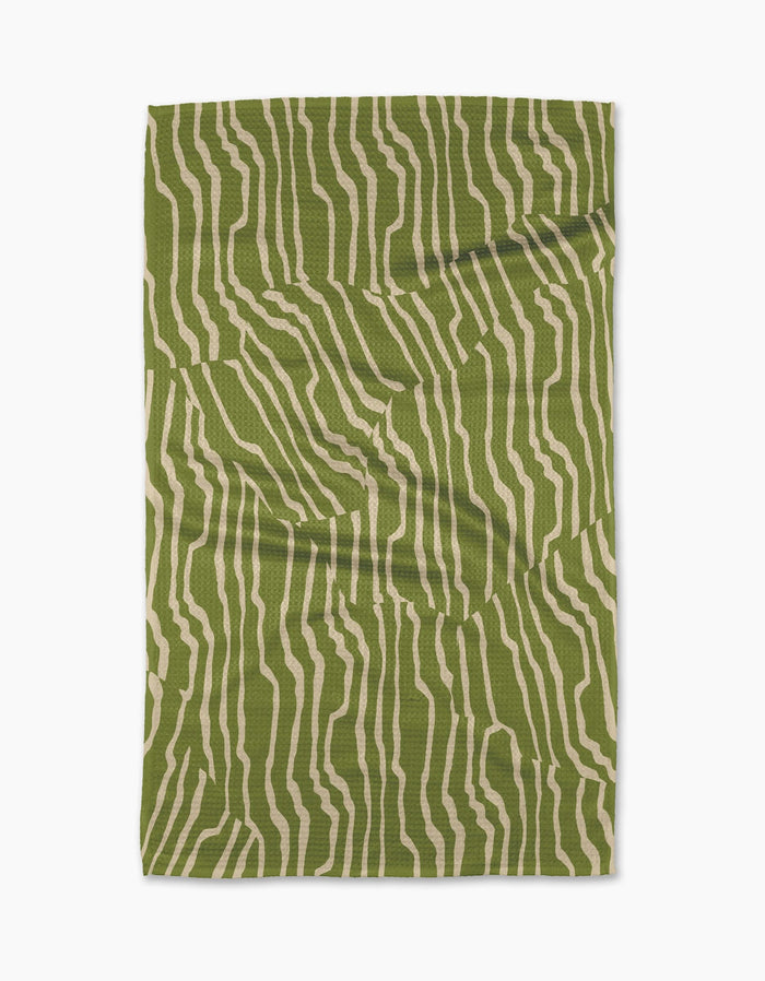 The Geometry Stripe Funk Grounds Green blanket, featuring an abstract green and beige wavy stripe pattern, is crafted from soft Geoweave fabric and shown laid flat on a white background.