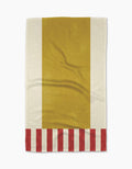 The Geometry Striped Heart Yellow tea towel features a bold vertical yellow center, off-white sides, red and off-white stripes along the bottom, and is crafted from sustainable recycled materials.